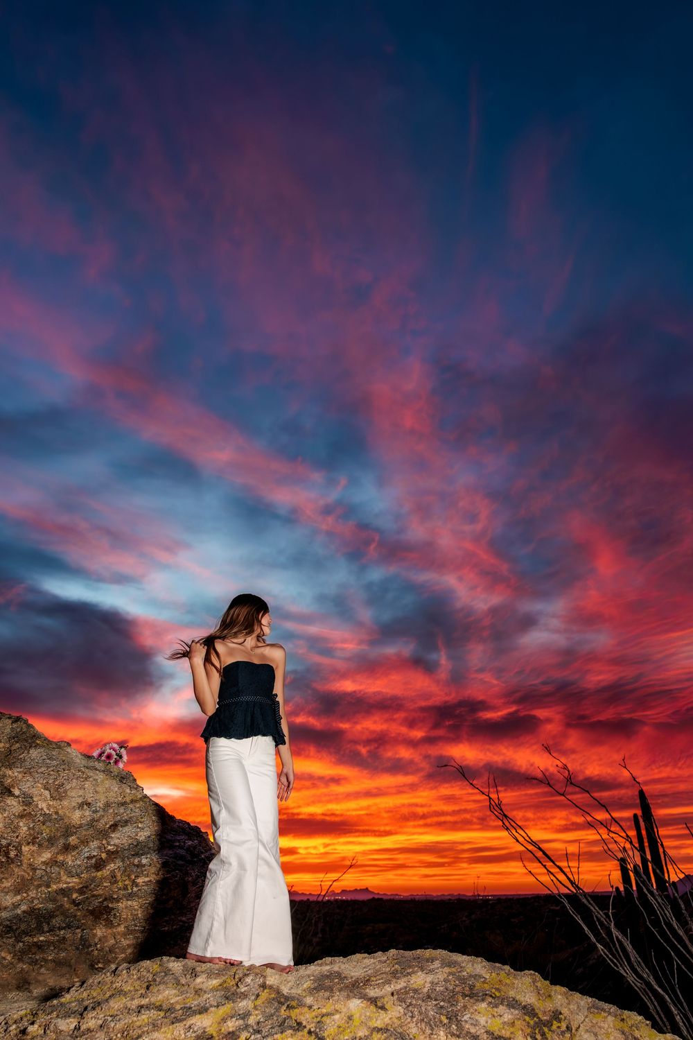 Tucson, AZ senior girl in the desert at golden hour with a beautiful sunset on big rocks