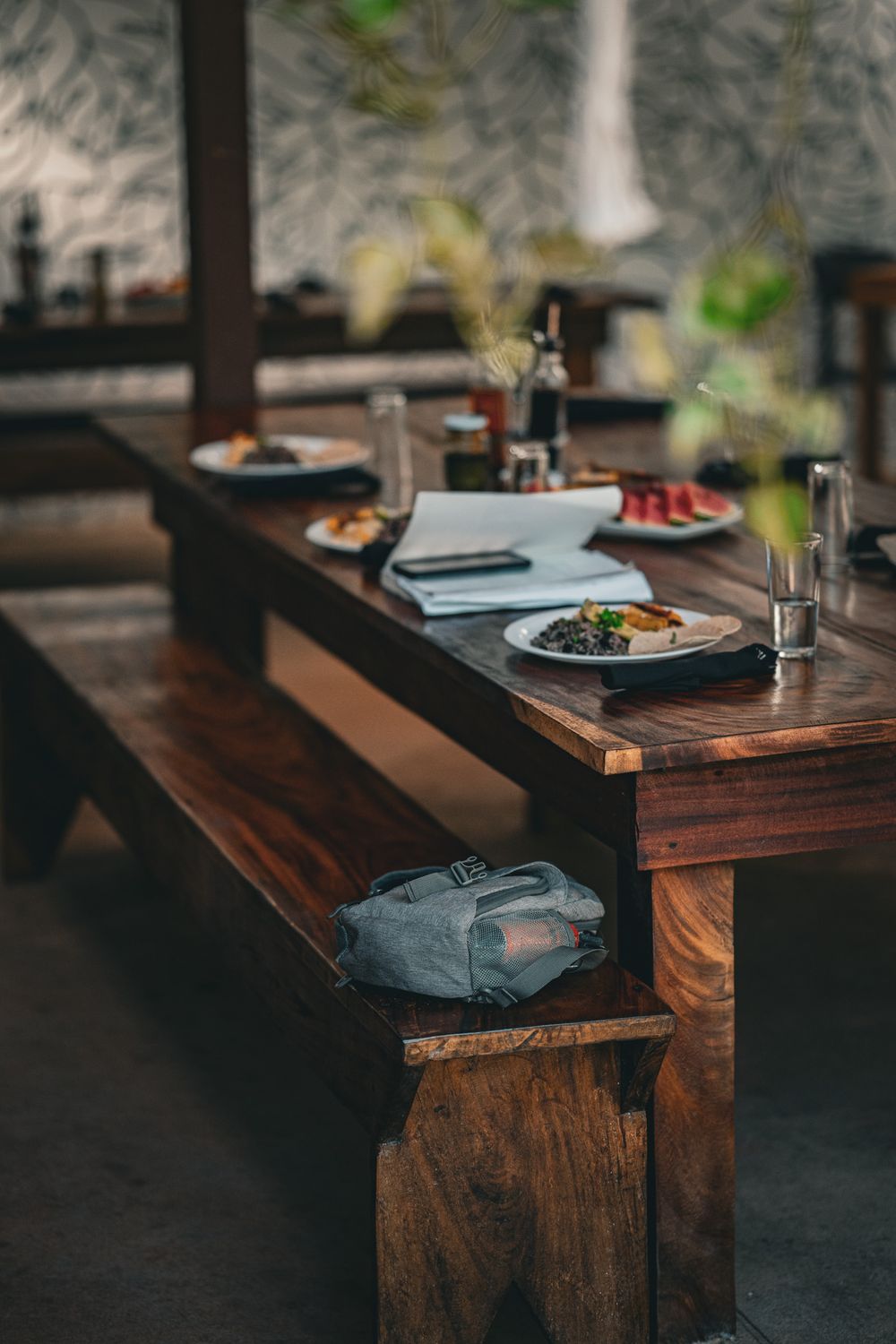 Rustic wooden dining table setup with plates and natural decor in a restaurant.