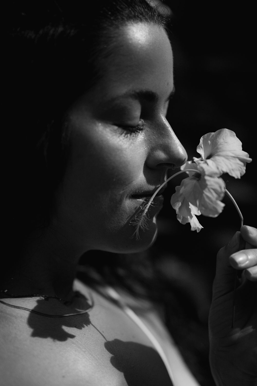 Artistic black and white portrait with delicate white flower.