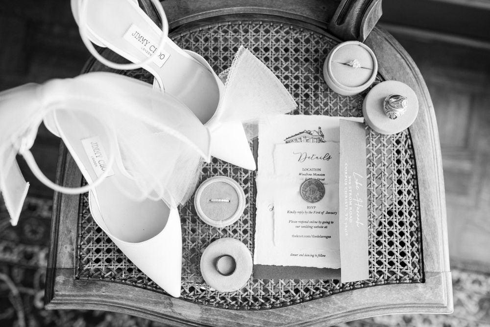 Wedding details arranged on a silver tray including invitations and white ribbons.