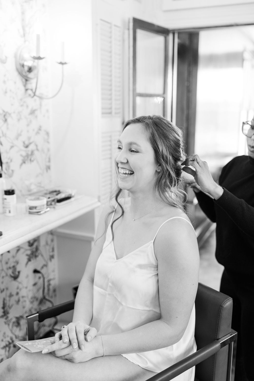 A candid black and white moment during wedding preparation.
