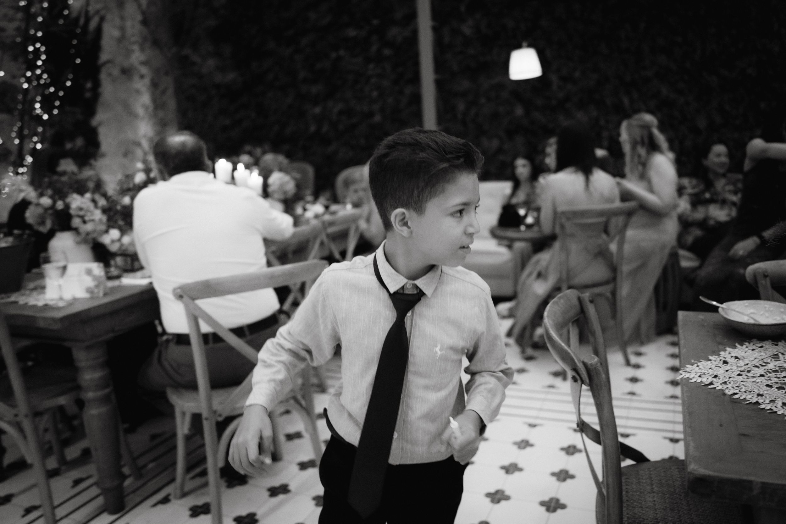 Young boy in formal attire dancing at a wedding reception.