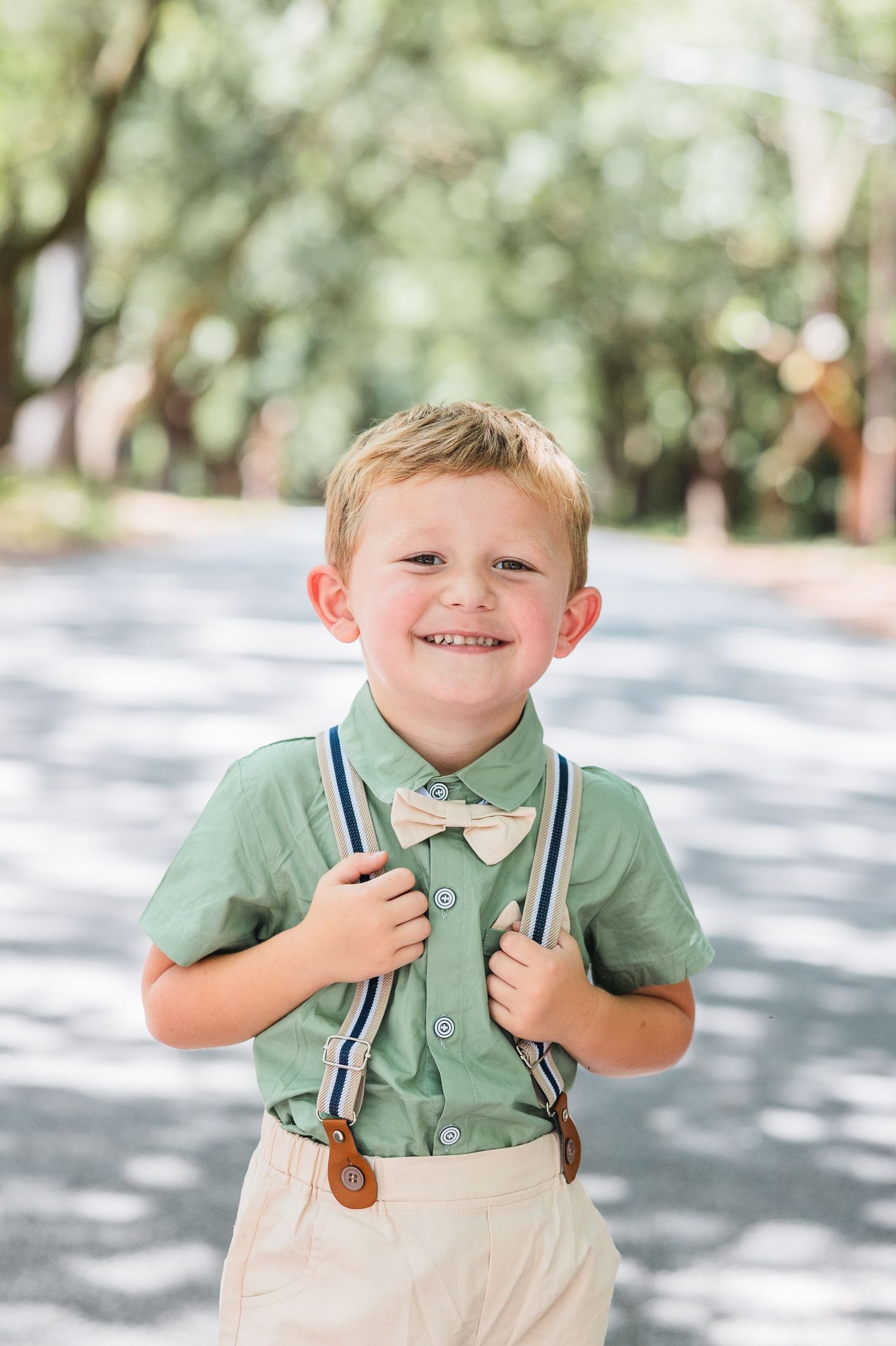 Portrait series of a young boy in green polo and suspenders smiling at the camera.
