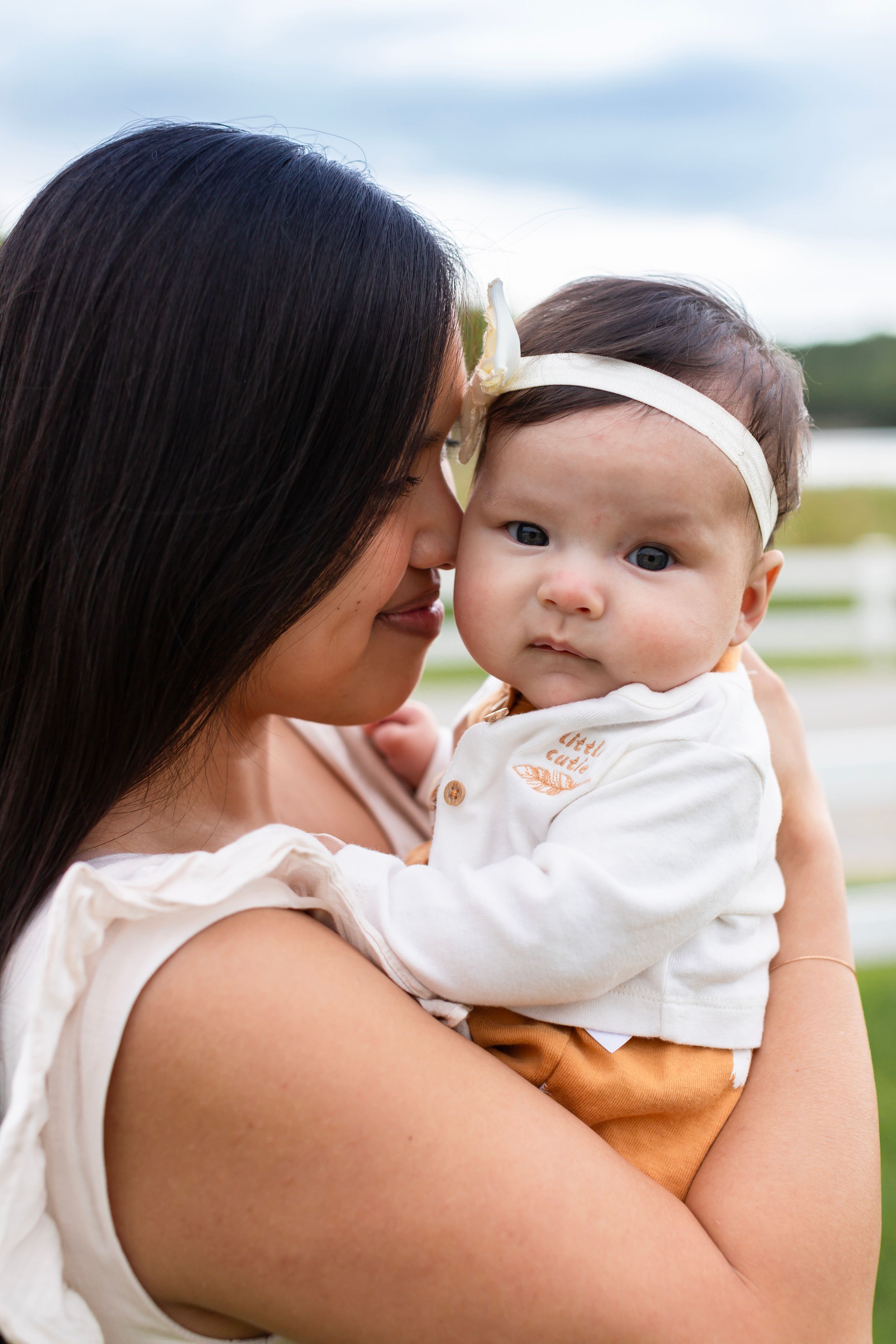 A tender moment captured outdoors with soft natural lighting.