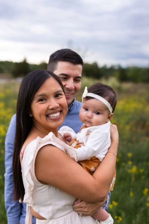 Outdoor family portrait in field of yellow wildflowers.
