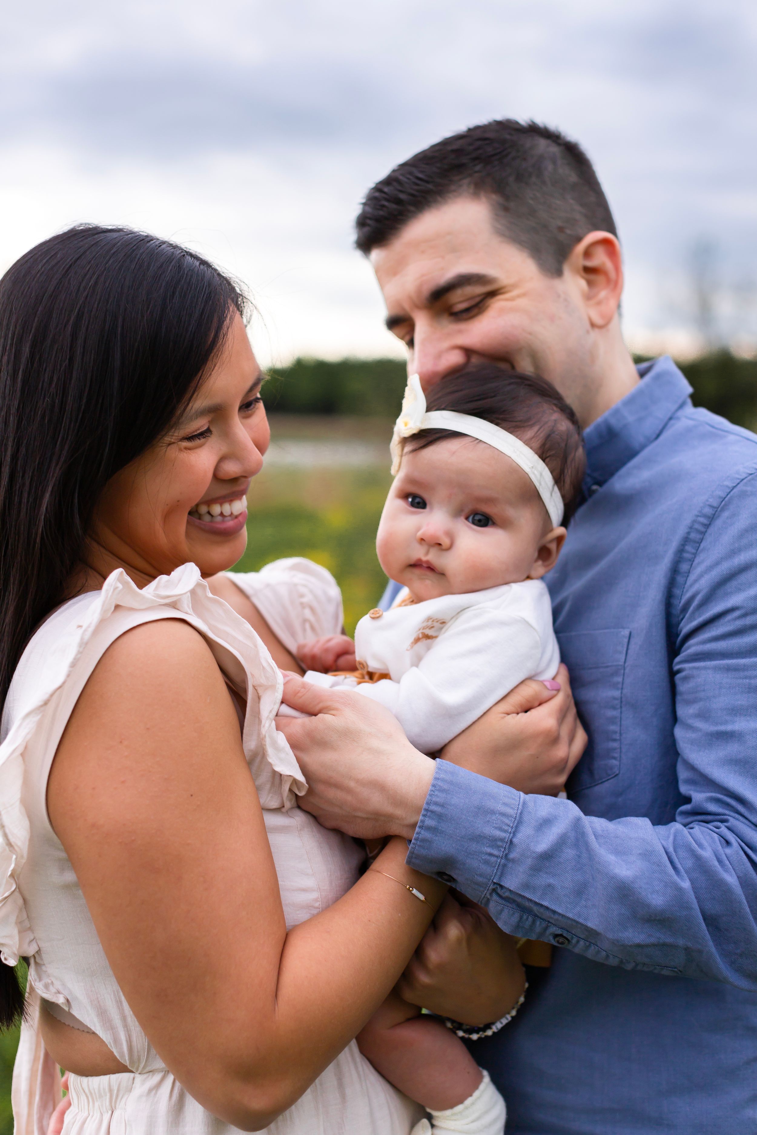 A sweet family moment captured outdoors with joyful expressions and natural lighting.