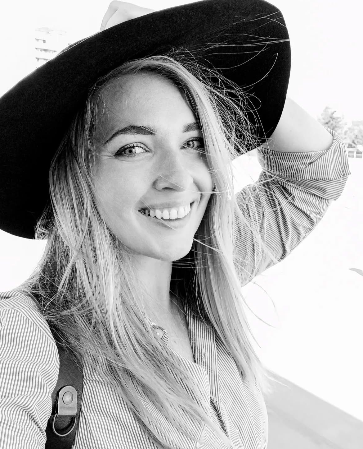 Artistic black and white portraits showing someone in a wide-brimmed hat with flowing hair.
