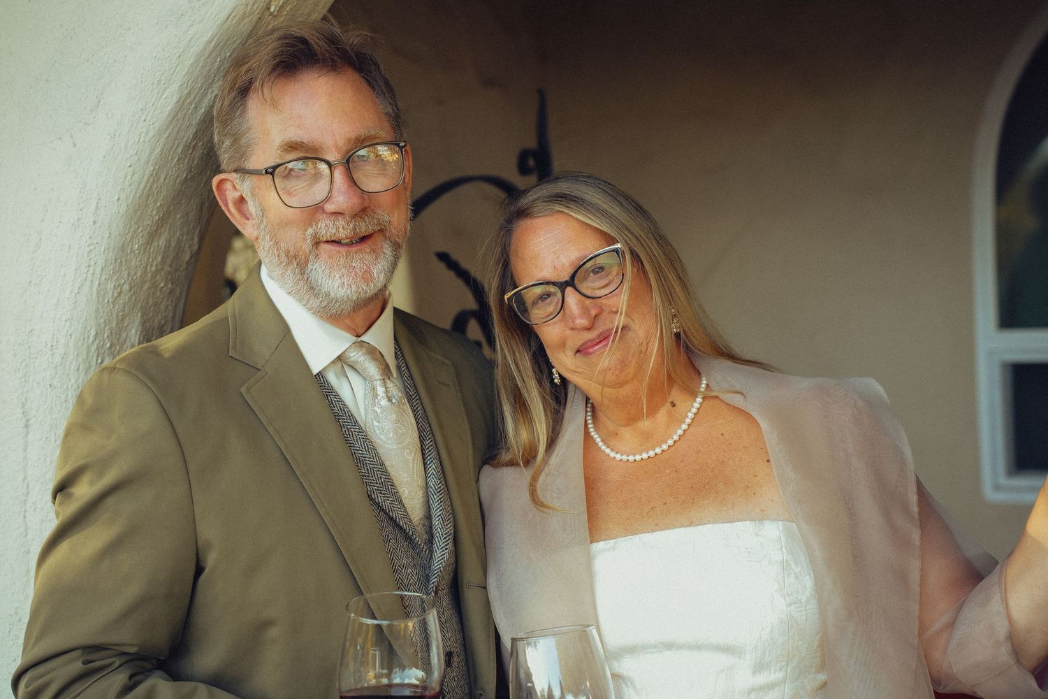A joyful wedding couple shares a tender moment during their celebration at an indoor venue.