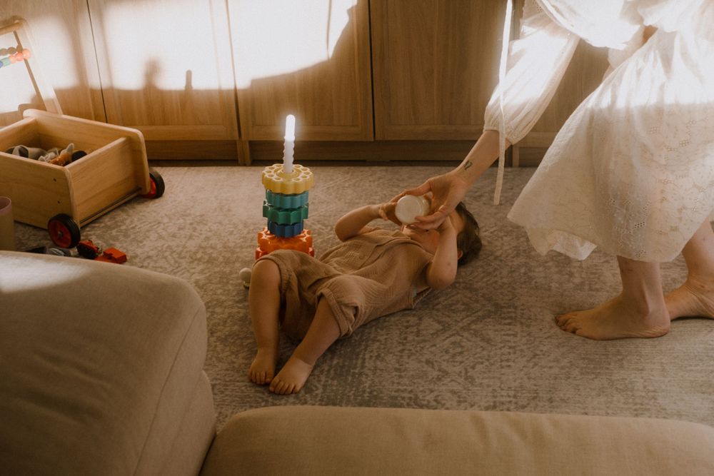 Warm-toned interior photographs showing toys and natural light on a carpeted floor.