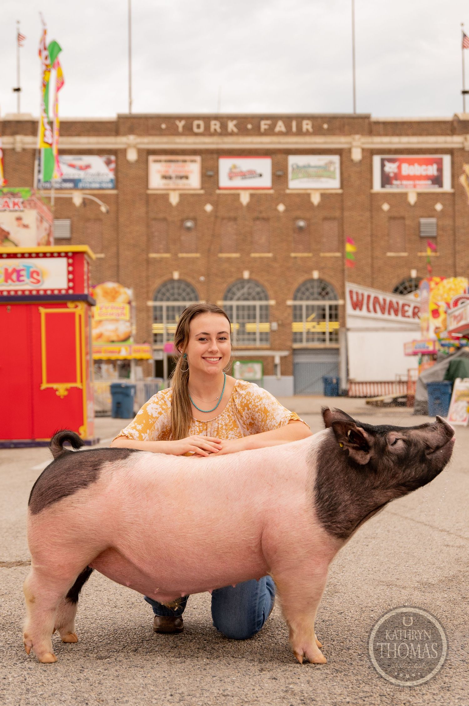 A large show pig poses with its handler in front of the York Fair building.
