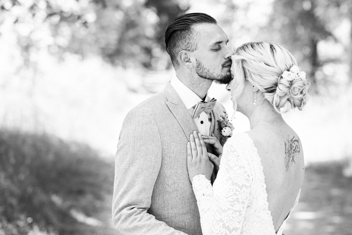 Bride and Groom kissing under a tree in a sunny farm