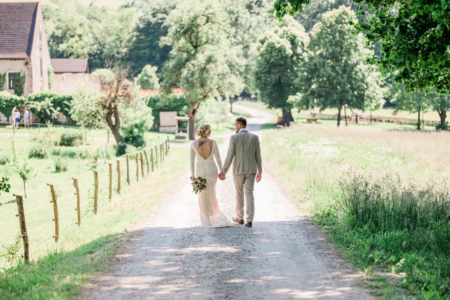 Bride and groom walking in sunny path on a beautiful farm in Nyon Switzerland