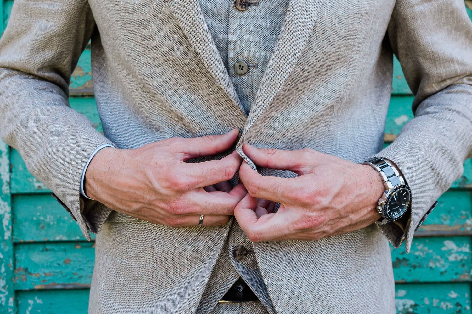 groom buttoning his jacket in Switzerland getting ready for his wedding
