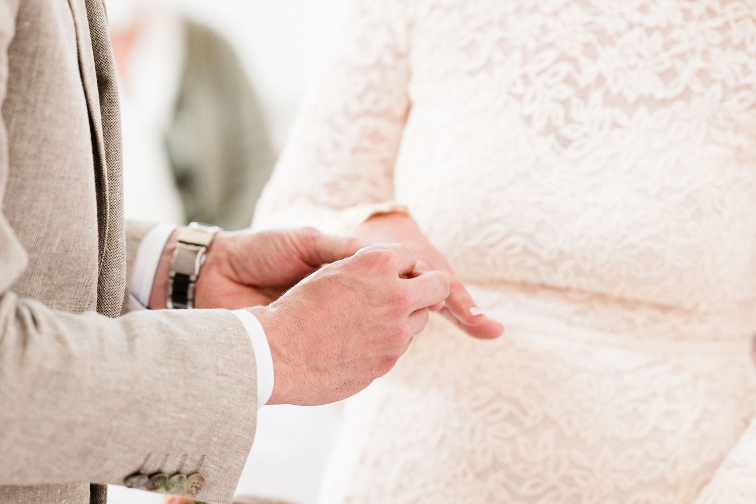 Groom putting ring on bride during wedding in Nyon, Switzerland