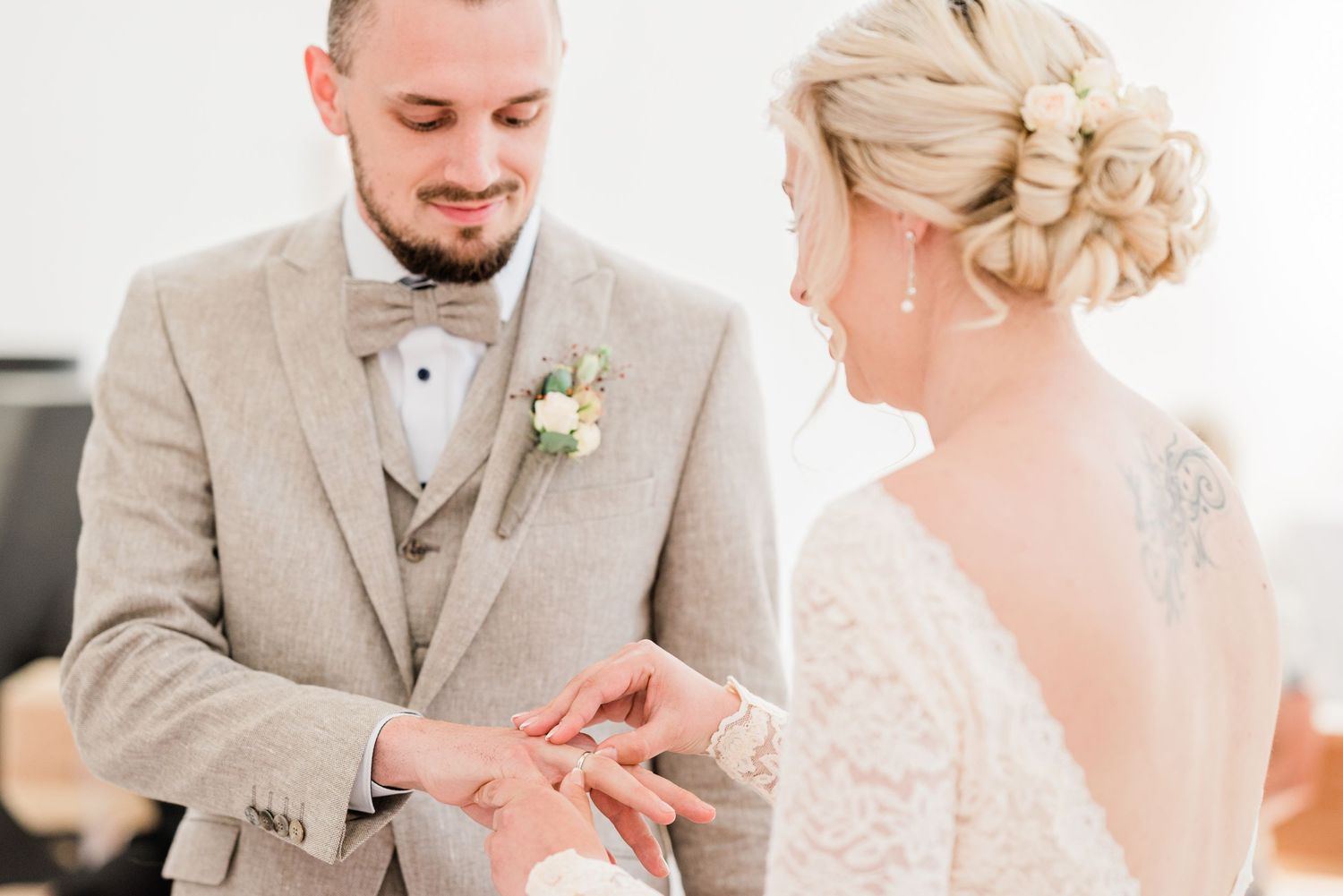 Bride putting ring on groom during their wedding in Nyon, Switzerland