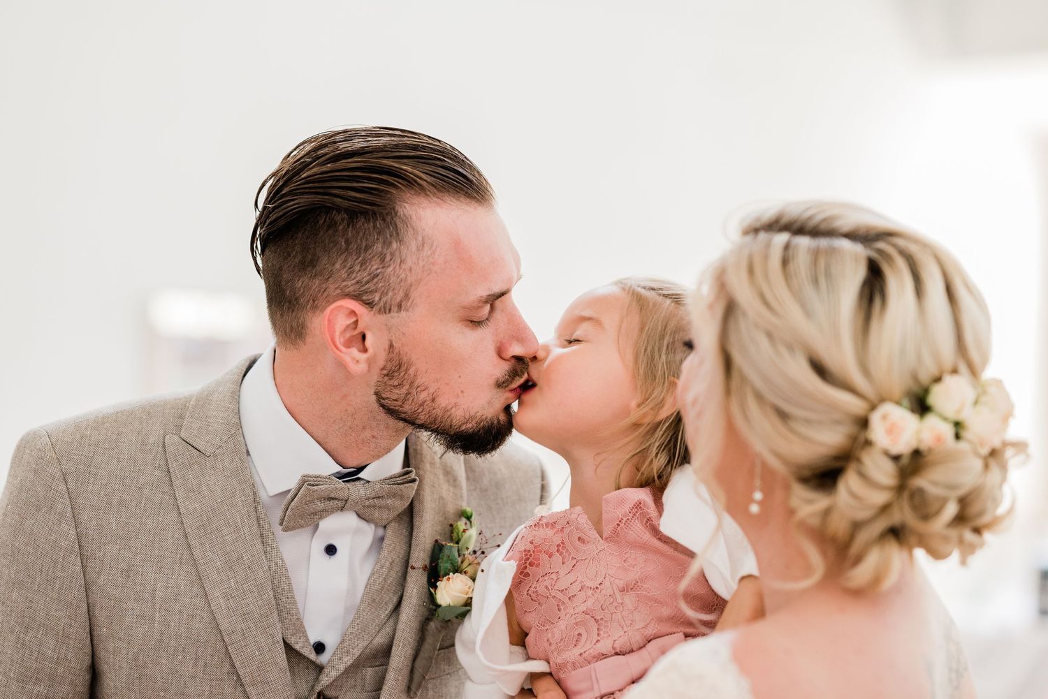 Groom kissing his daughter at the wedding
