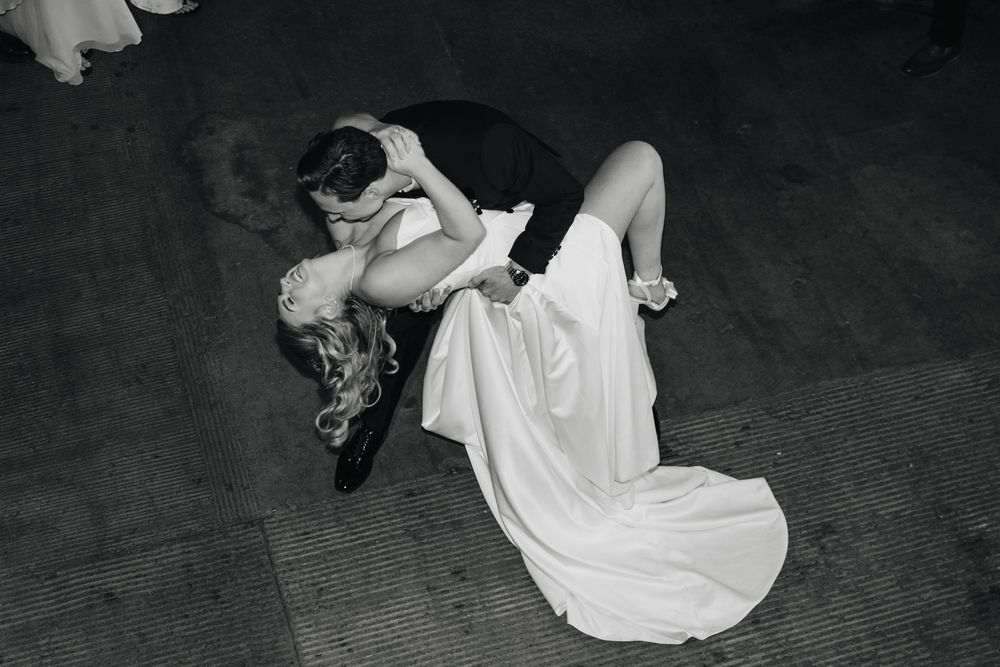 A dancer in a flowing white dress performs a dramatic spinning movement captured in a black and white photograph.