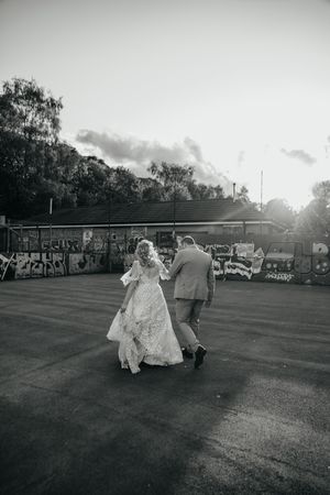 A couple dances romantically on a grassy lawn at sunset in black and white photography.