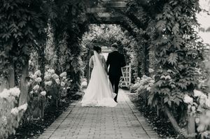 A black and white photo collage of wedding couples walking down garden paths surrounded by lush greenery and trees.