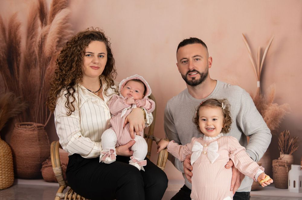 Family portrait with boho decor featuring pampas grass and neutral tones.