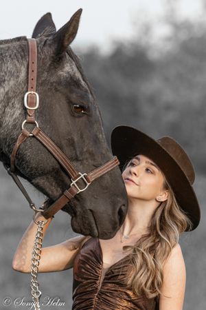 An artistic black and white portrait showing a close connection between horse and handler.