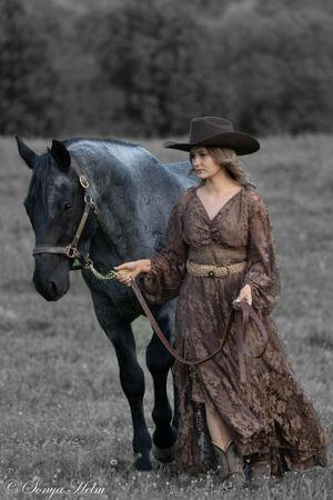 A graceful black horse and western-styled companion in period dress pose in a monochrome field setting.