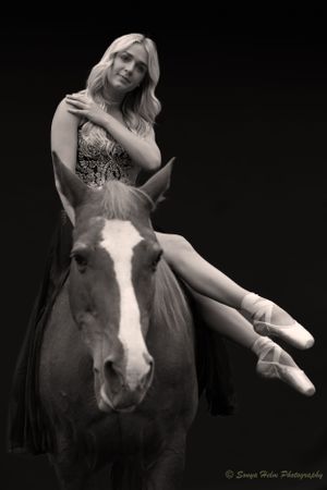 A black and white portrait shows a dancer reclining on a horse in artistic pose.