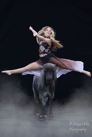 Artistic dance sequence of a performer riding bareback on a horse through misty darkness.
