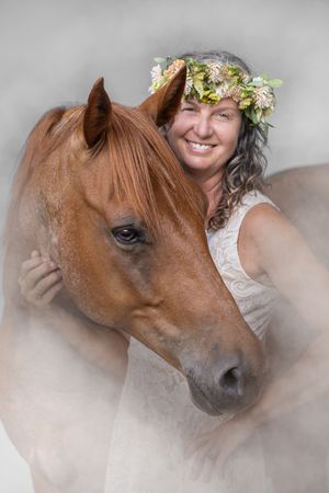 A brown horse and someone wearing a floral crown pose together in a dreamy, soft-focus portrait series.
