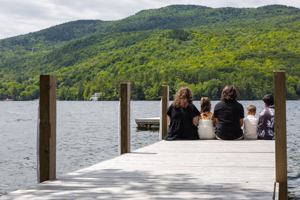 A scenic lakeside view with mountains and forest in the background.