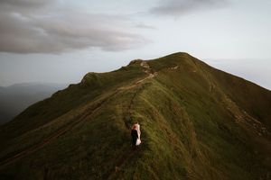 Dramatická panoramická svadobná fotka nevesty a ženícha na horách