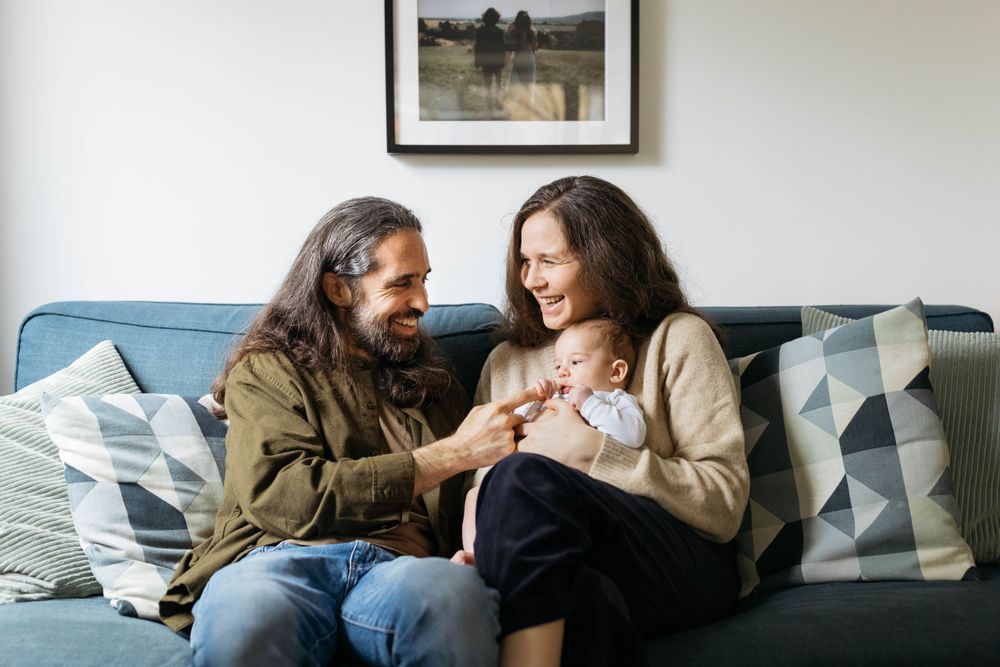 mum and dad holding their two month old baby boy in their arms