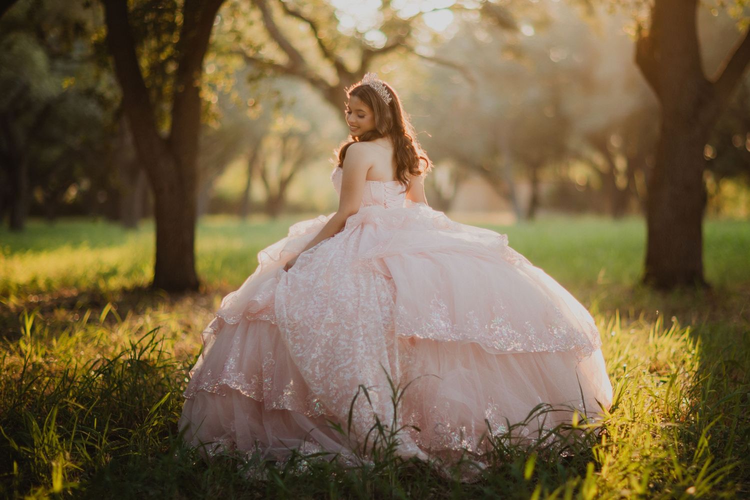 Young woman in white corset top gazes thoughtfully by window in dramatic lighting.