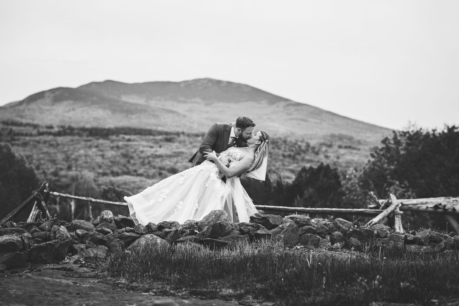 Bride holding cascading bouquet of white roses, eucalyptus, and golden dried wheat grasses.