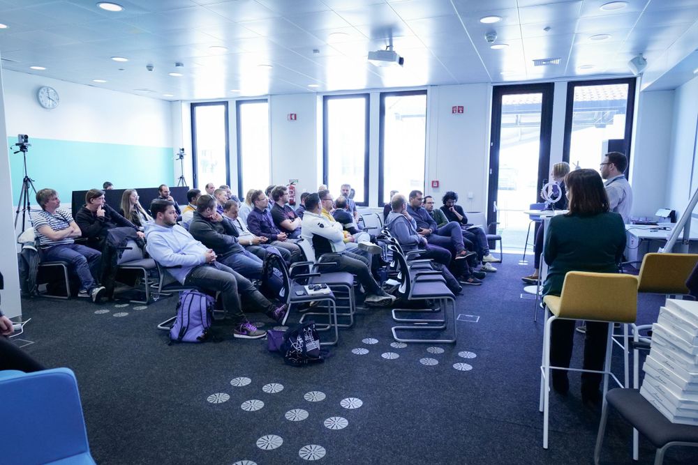 Attendees seated in a bright conference room listening to a presenter at a seminar.