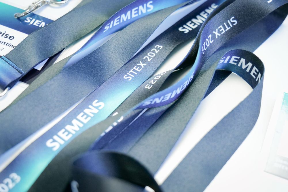 Siemens SITEX 2023 branded lanyards displayed on a white surface.