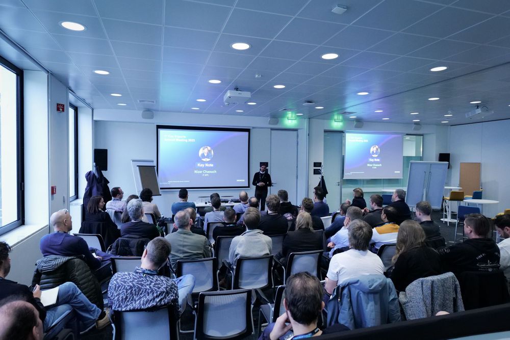 Business professionals attend a Siemens corporate presentation in a modern conference room.