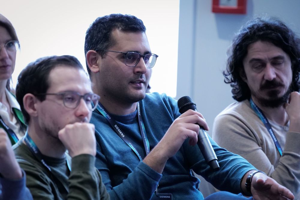 Man speaking into microphone during a panel discussion at a professional conference.