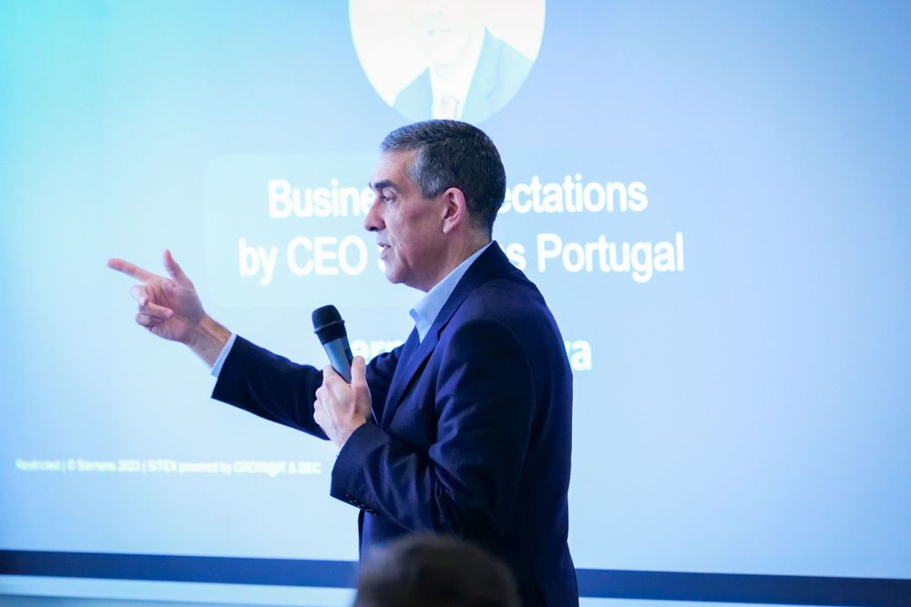 Business executive in suit delivering a speech at a corporate presentation event.