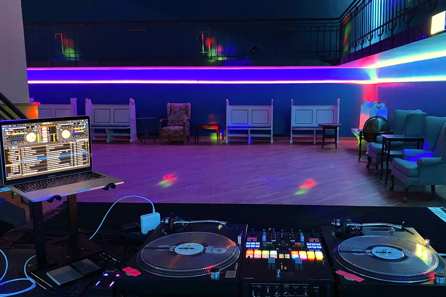 Modern nightclub interior with neon lighting and DJ equipment creating an immersive party atmosphere.