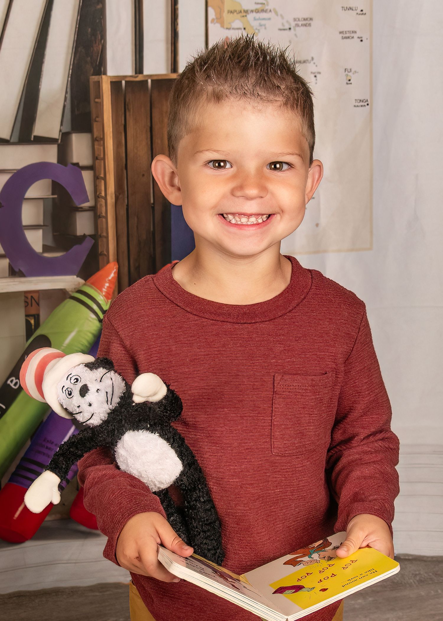 School portrait setting with colorful letters and stuffed toys against a map background.