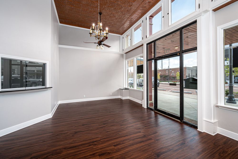 Modern open concept commercial space with wood floors and large windows.