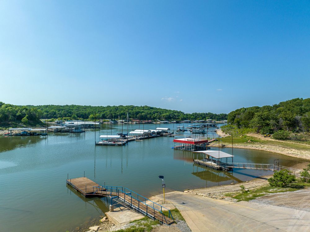 Marina with docked boats and wooden piers along a calm waterway surrounded by green shoreline.