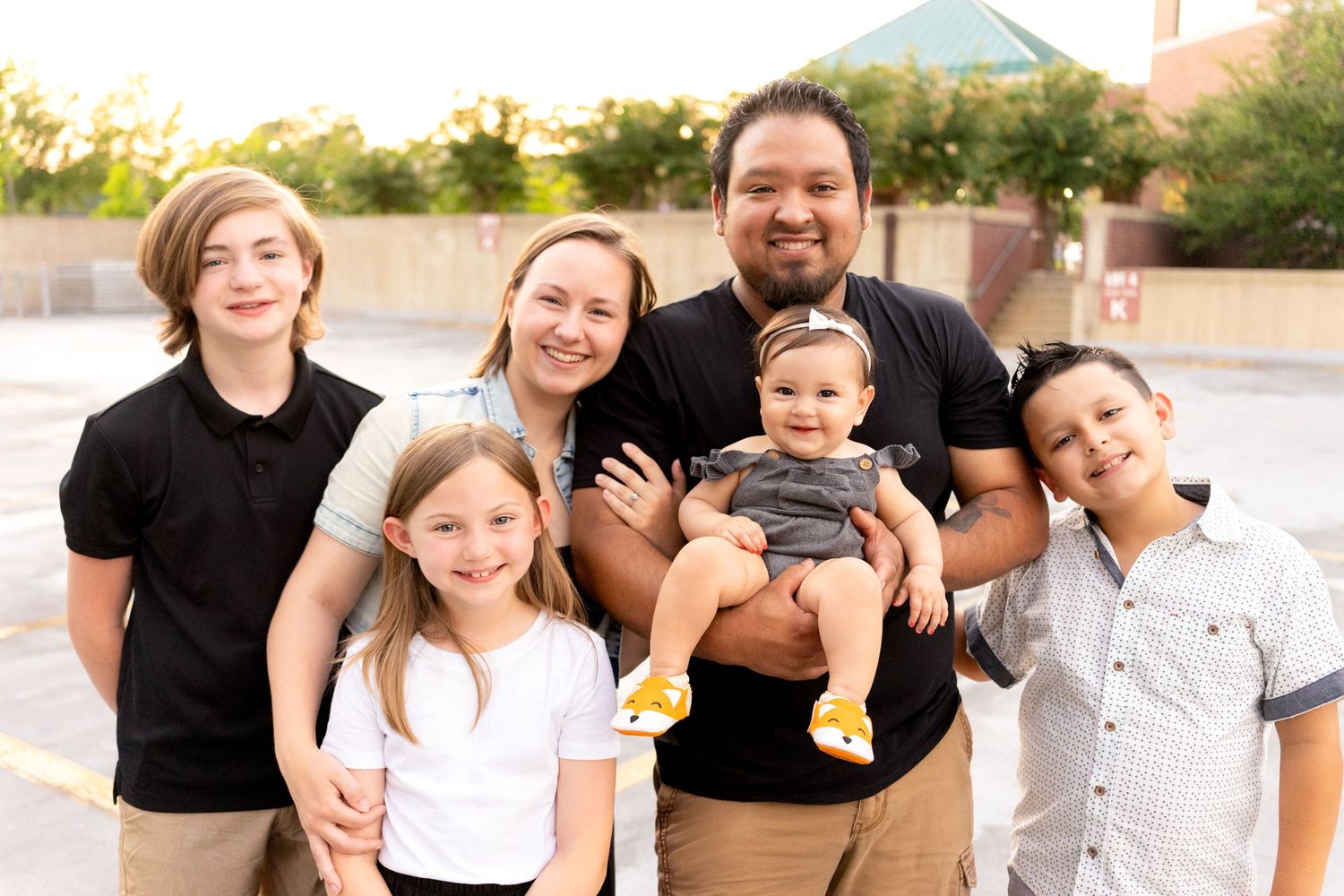 Happy family group posing together outdoors on a sunny day.