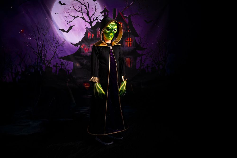 Spooky Halloween scene with silhouetted bare tree against purple sky with full moon and haunted house in background.