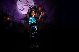 A ghostly blue figure illuminated in darkness stands near bare trees against a spooky purple night sky with bats.