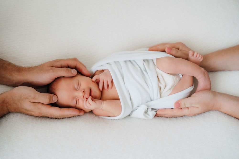 Close-up series of hands gently cradling a baby's tiny feet against white background.