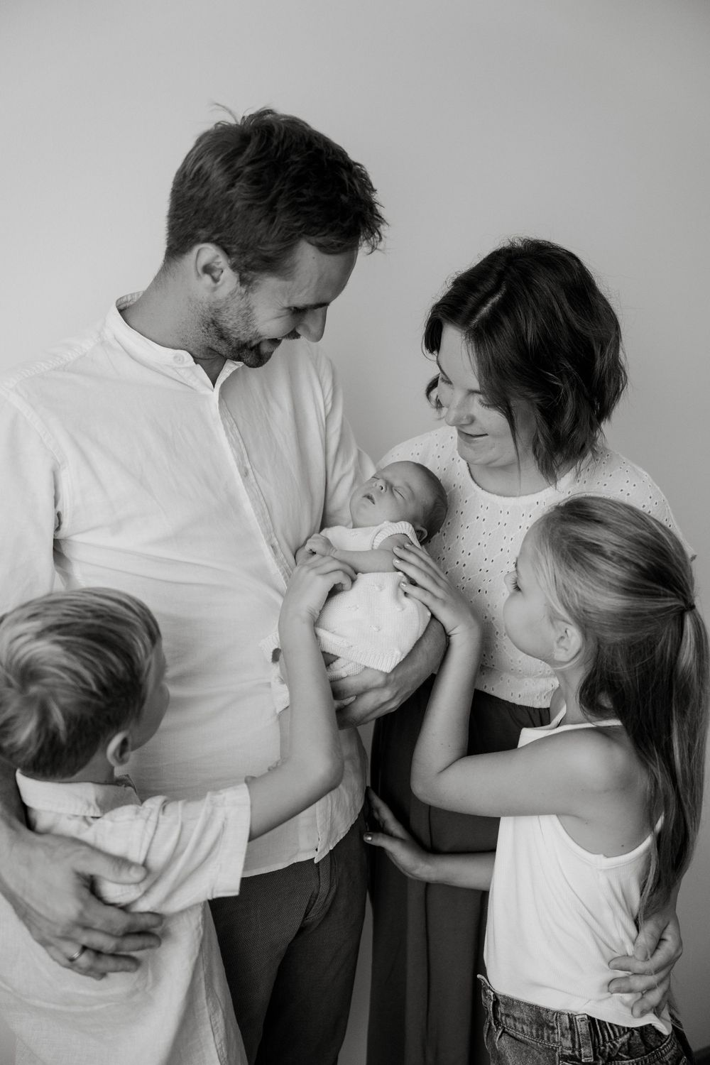 Family sharing tender moments together in black and white portrait series.