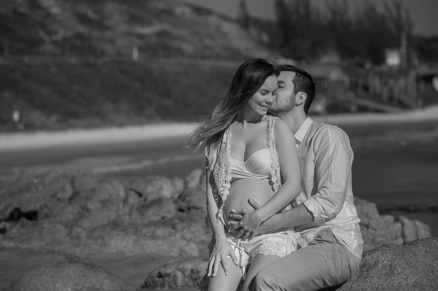 A romantic black and white photo of a couple on rocky terrain.