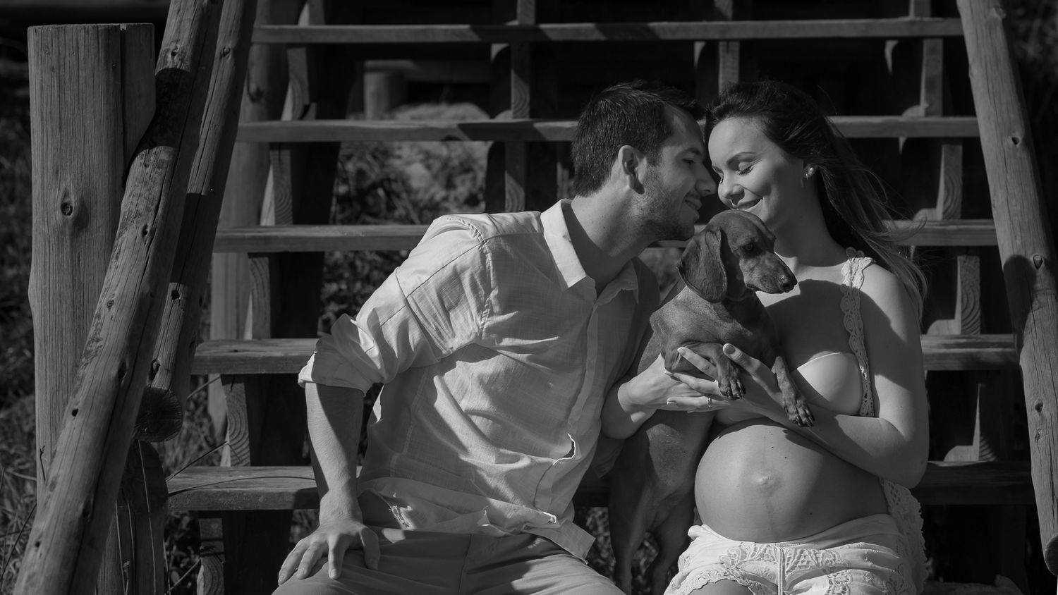 A tender black and white moment of two people sitting together on wooden steps.